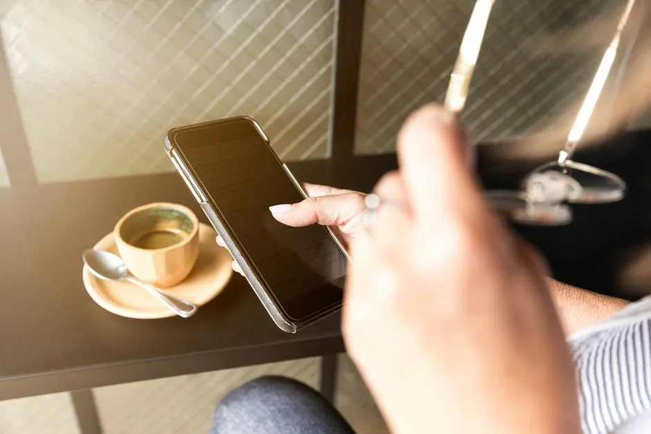 A person reading Scripture on their phone over morning coffee, the daily habit that actually finishes a year-long plan