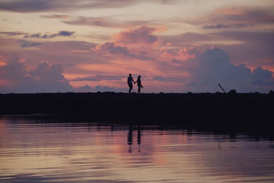 A couple holding hands at sunset, strength found in walking together