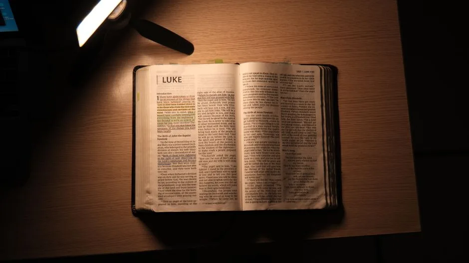 A lamp beside an open Bible at night. Scripture lighting the way forward