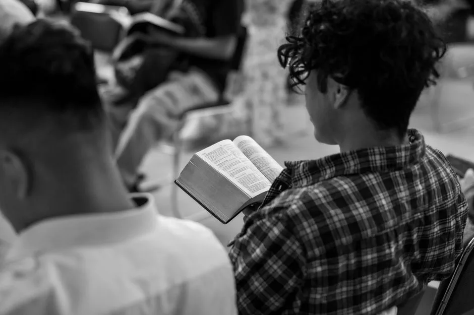A man sitting alone outside in the early morning, choosing to start his day in Scripture before the demands of the day begin