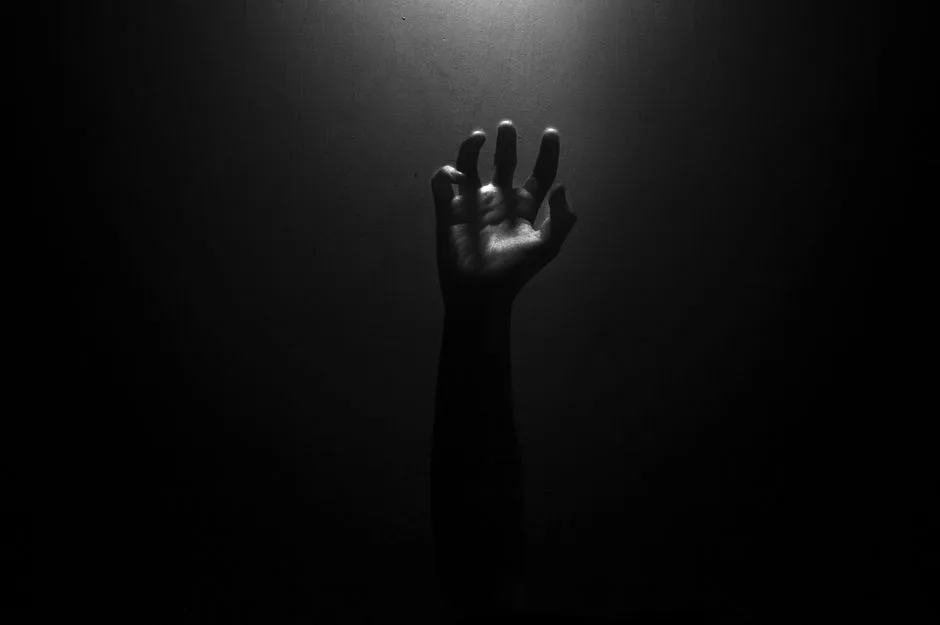 A hand reaching toward the light out of darkness. God's nearness in the middle of fear