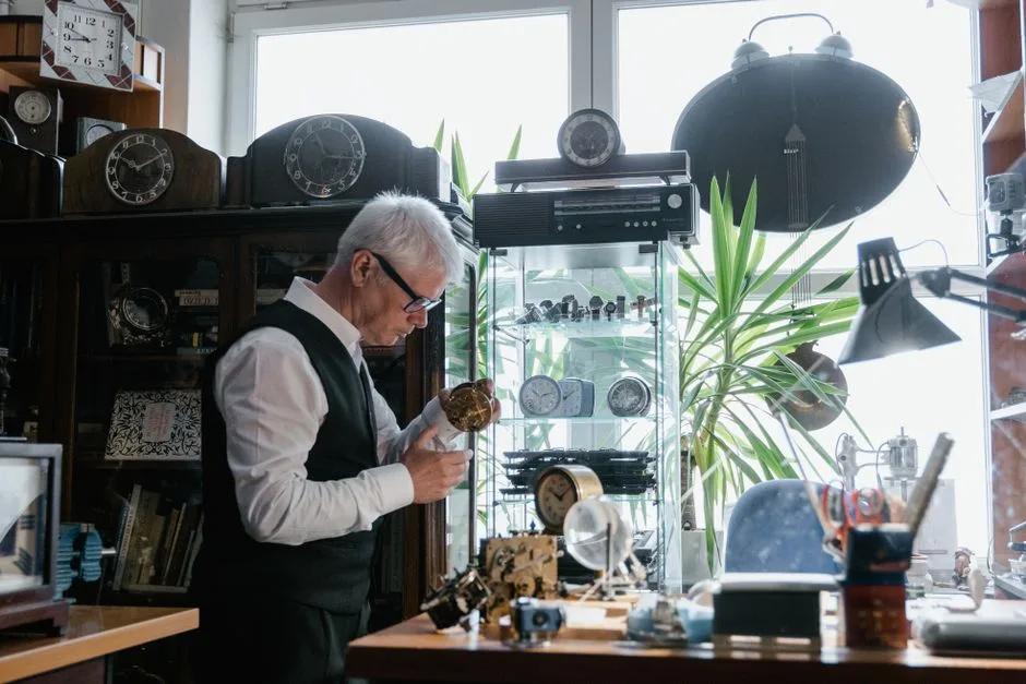 A retired man working part time at a small shop counter