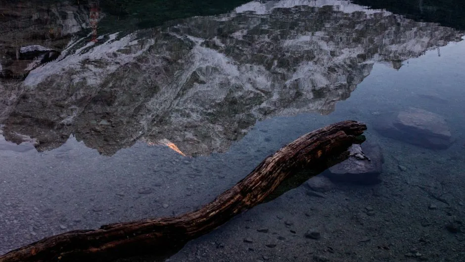 Still water reflecting distant mountains, perfect peace for a steadfast mind