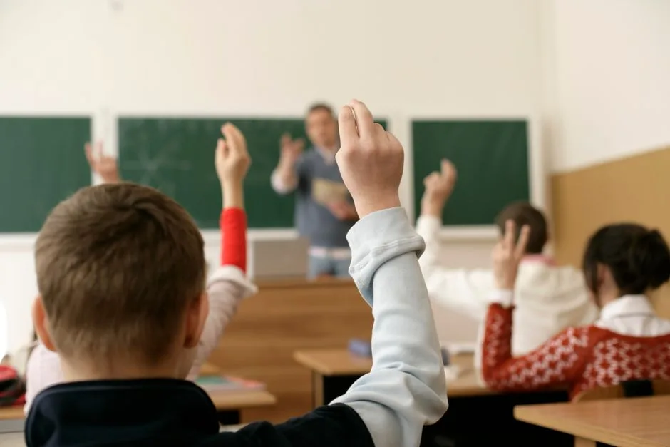 Kids raising their hands to answer a Bible trivia question