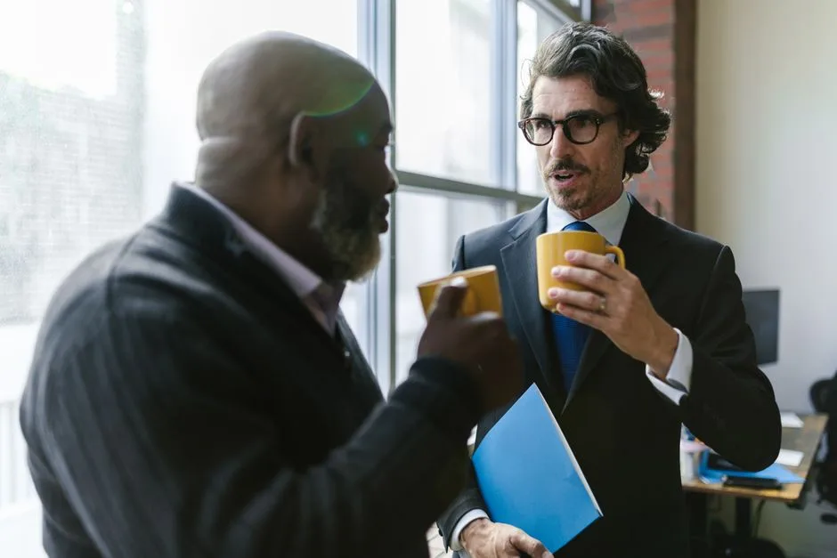 Two older men talking over coffee at a table