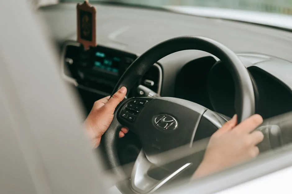 Calm hands resting on a steering wheel — the discipline of a gentle response instead of a harsh one