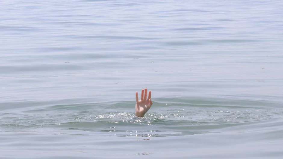 Hands emerging from water into light — the picture of new life baptism represents