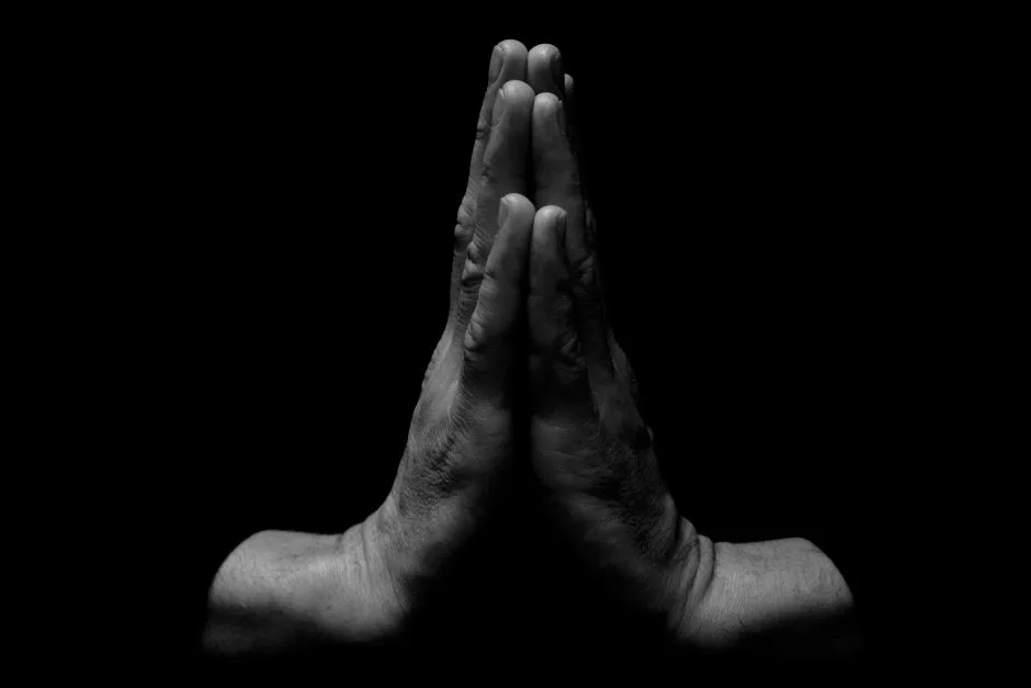 Hands clasped in prayer against a stormy sky — trust chosen in the middle of real fear