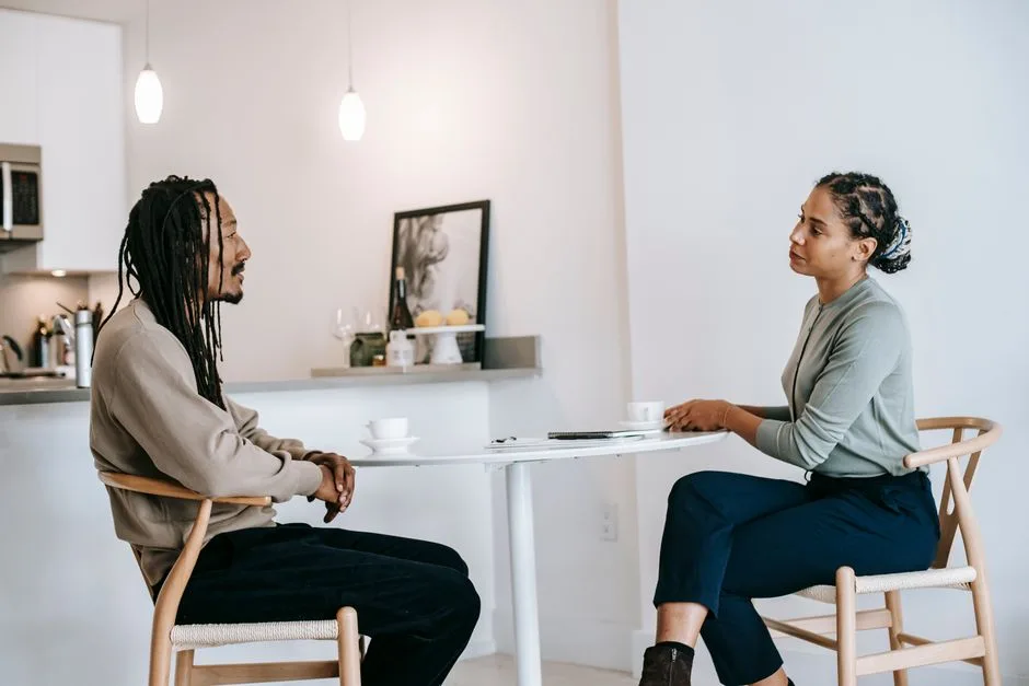 Two people in conversation, one listening attentively — the practice of honoring others ahead of yourself