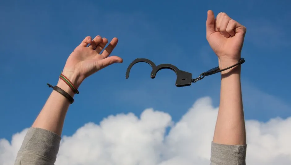 Hands releasing a weight into open light — the promise of faithful forgiveness following honest confession