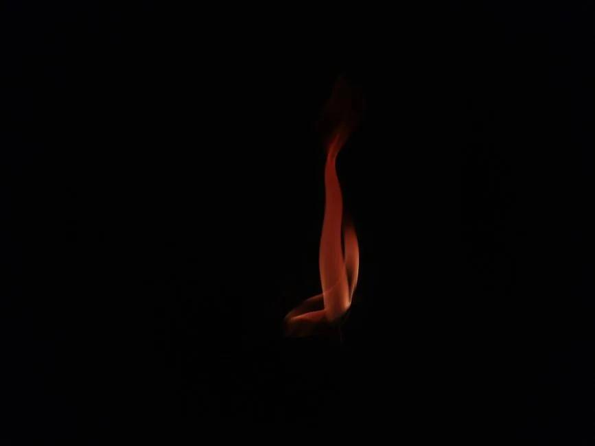 A single flame casting three points of light — the mystery of one God in three persons