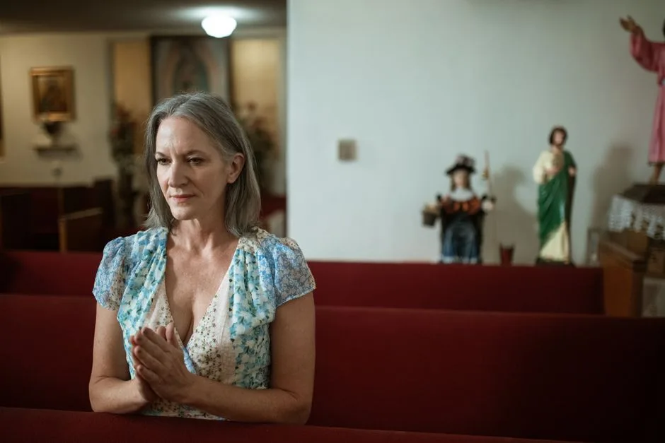 An older woman's weathered hands folded in quiet prayer — the steady faith God defends and provides for